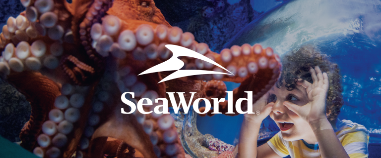 The SeaWorld logo over a picture of a boy staring at a pink octopus in an aquarium